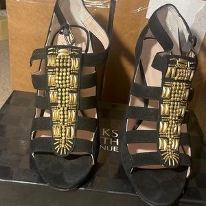 Black suede open toe pump with gold embroidery in the front.